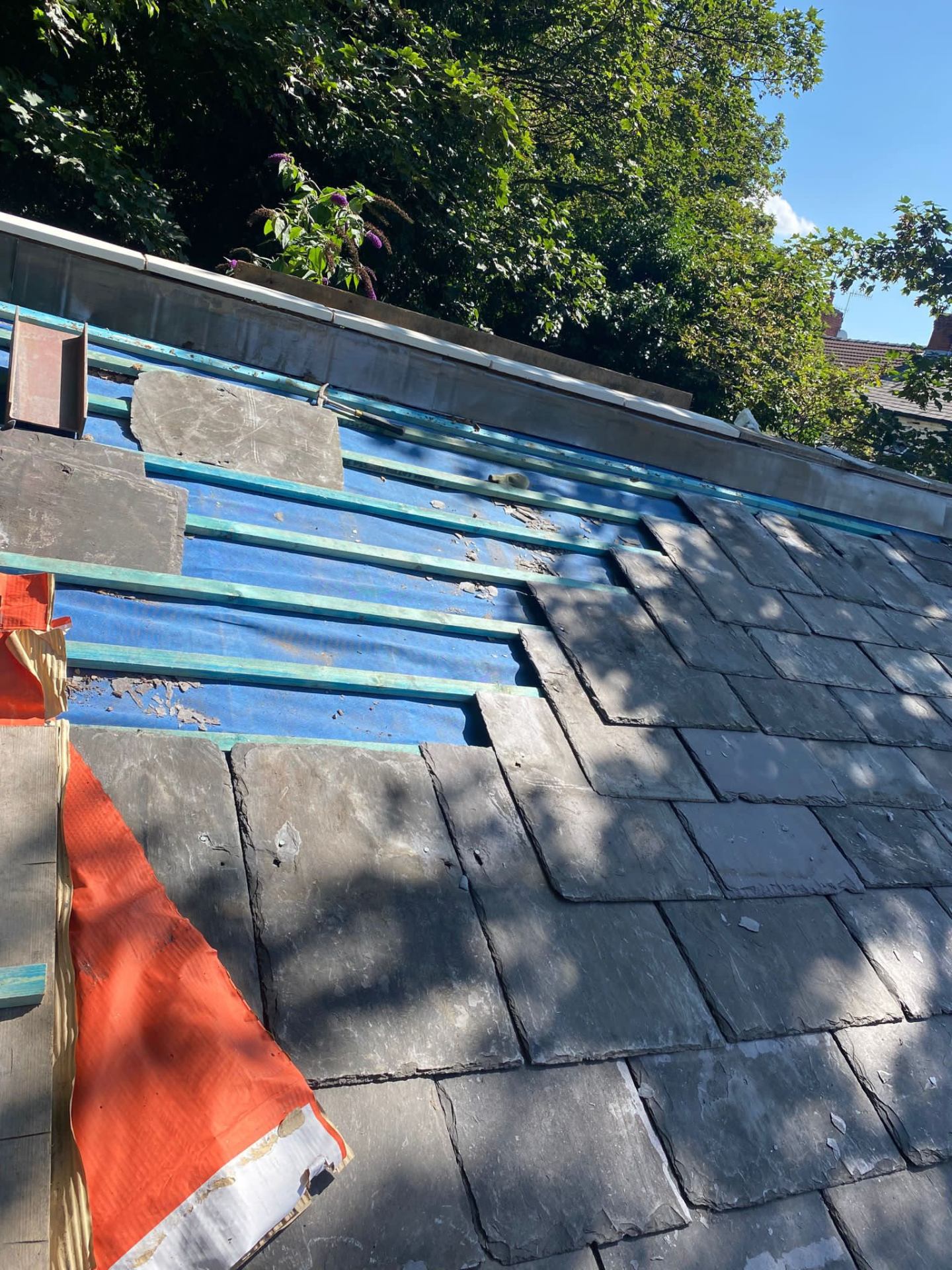 Mid-strip slate roof with new battens over breathable membrane and salvaged slates below, RTC Roofing